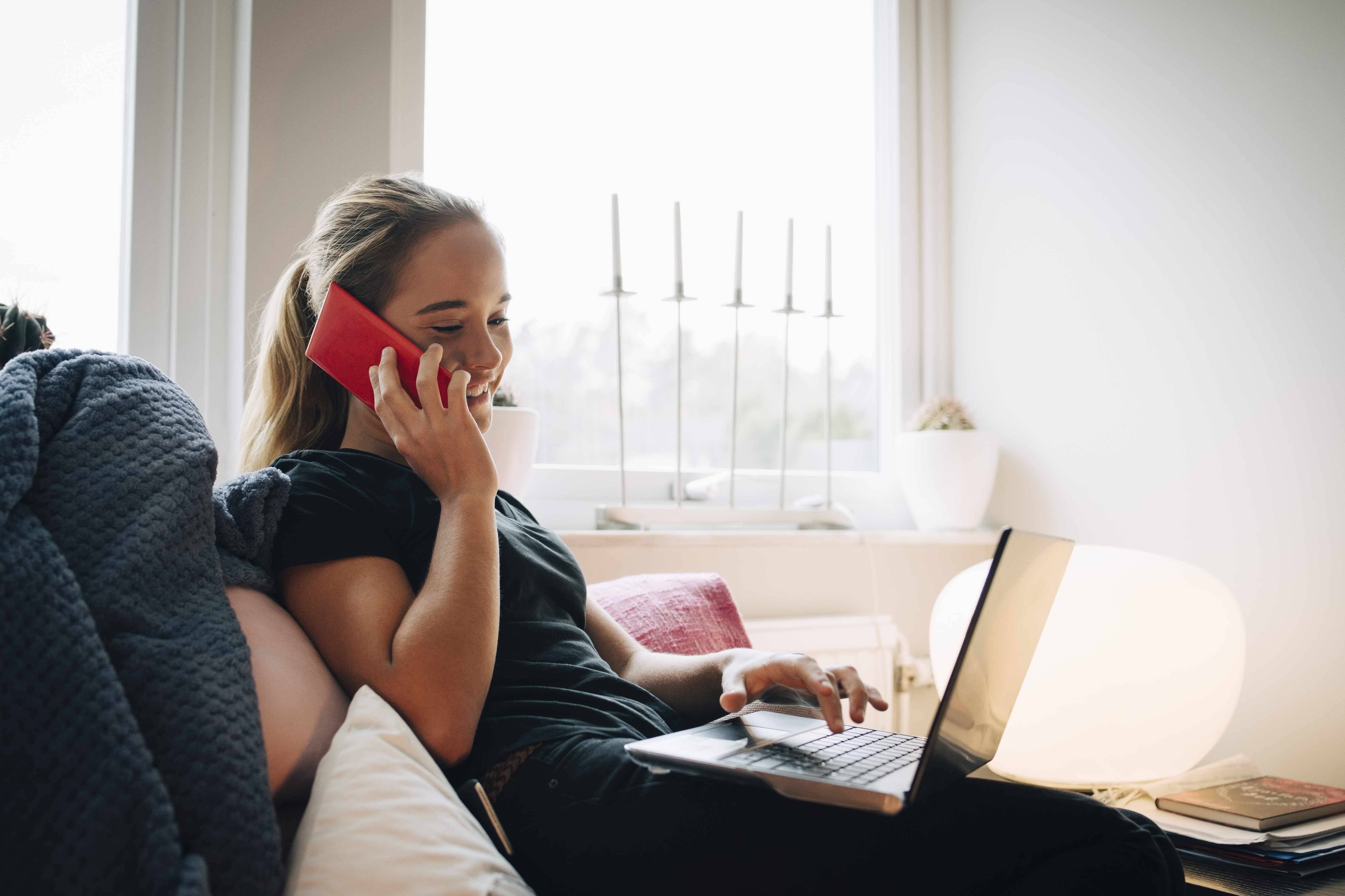 woman smiling while on the phone and working