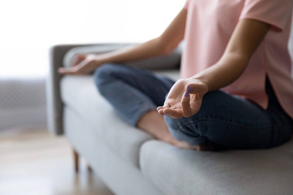woman meditating on sofa
