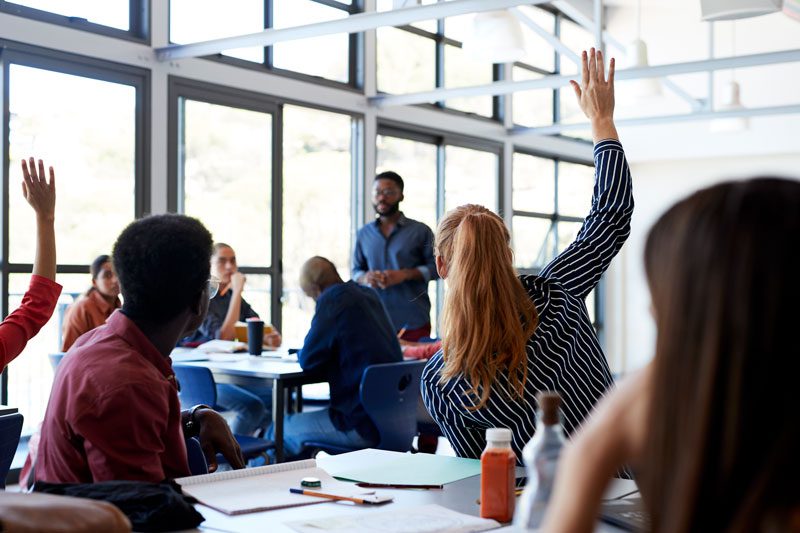 class of students with hands up