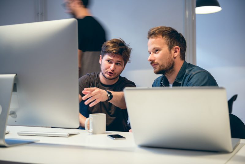 2 men looking at a computer