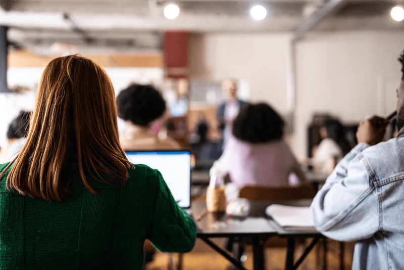 Girl with PC at the back of a classroom