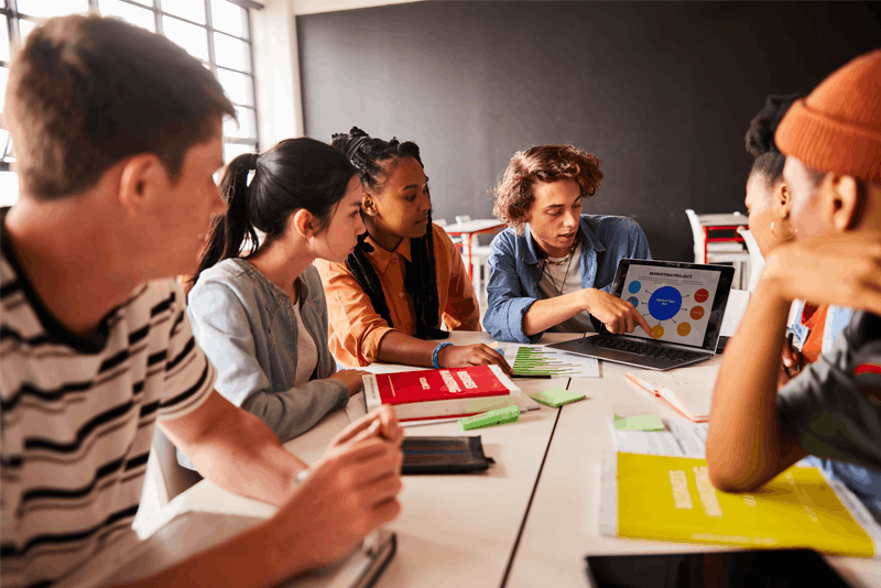 Students sitting around a table looking at a computer